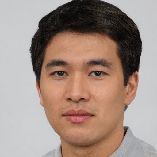 Joyful asian young-adult male with short  black hair and brown eyes