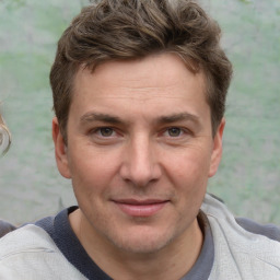 Joyful white adult male with short  brown hair and grey eyes