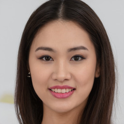 Joyful asian young-adult female with long  brown hair and brown eyes