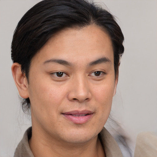 Joyful asian young-adult female with short  brown hair and brown eyes