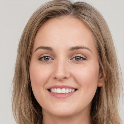 Joyful white young-adult female with long  brown hair and green eyes