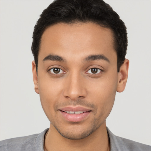 Joyful latino young-adult male with short  brown hair and brown eyes