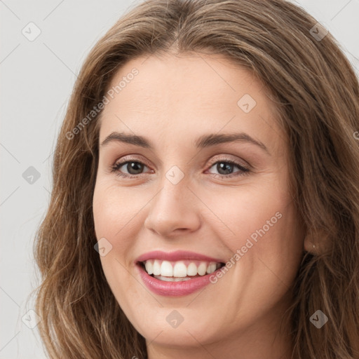 Joyful white young-adult female with long  brown hair and green eyes