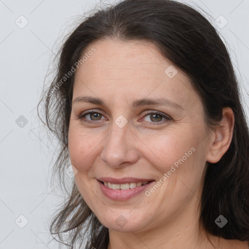 Joyful white adult female with long  brown hair and brown eyes