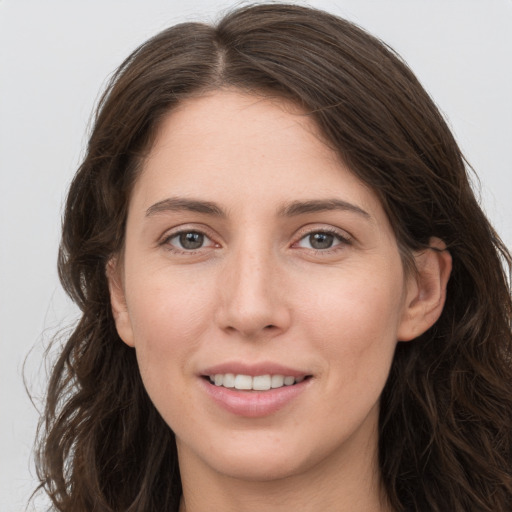 Joyful white young-adult female with long  brown hair and grey eyes