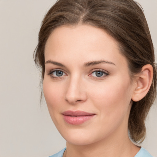 Joyful white young-adult female with medium  brown hair and grey eyes