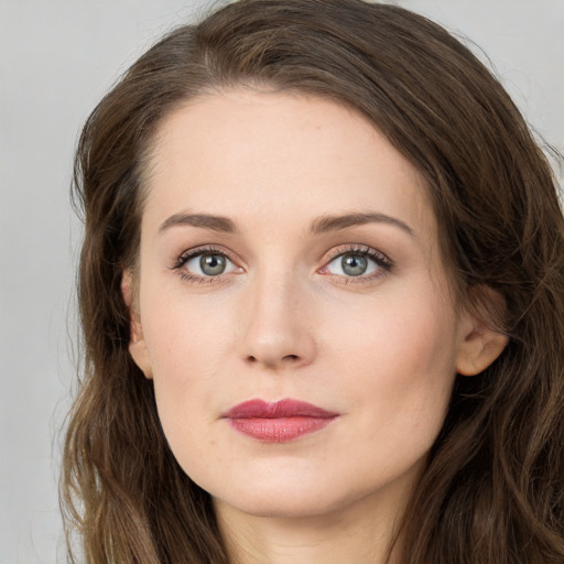 Joyful white young-adult female with long  brown hair and green eyes