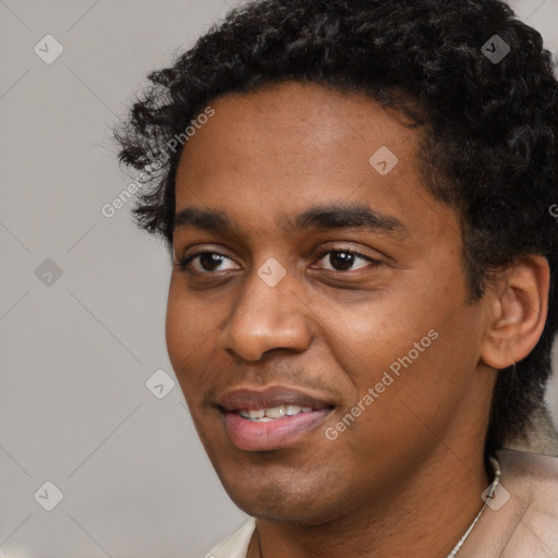 Joyful black young-adult male with short  black hair and brown eyes