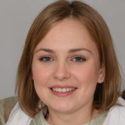 Joyful white young-adult female with medium  brown hair and blue eyes