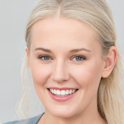 Joyful white young-adult female with long  brown hair and blue eyes