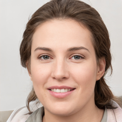 Joyful white young-adult female with medium  brown hair and grey eyes