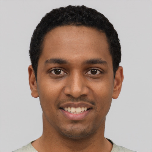 Joyful black young-adult male with short  black hair and brown eyes