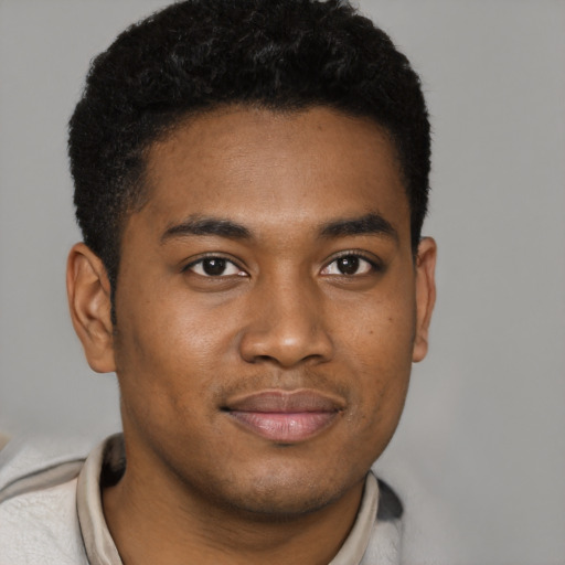 Joyful black young-adult male with short  brown hair and brown eyes