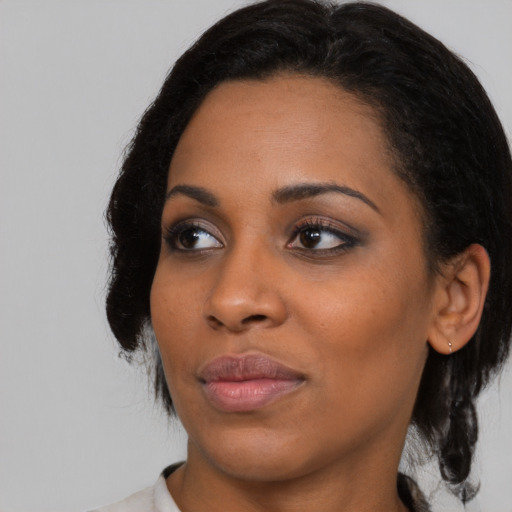 Joyful black young-adult female with medium  black hair and brown eyes