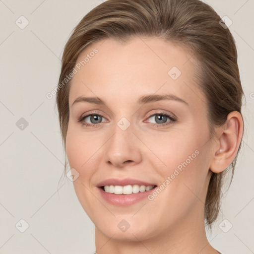 Joyful white young-adult female with medium  brown hair and grey eyes