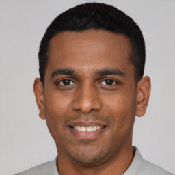 Joyful latino young-adult male with short  black hair and brown eyes