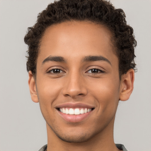 Joyful latino young-adult male with short  brown hair and brown eyes