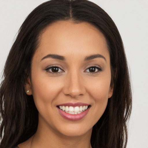 Joyful white young-adult female with long  brown hair and brown eyes