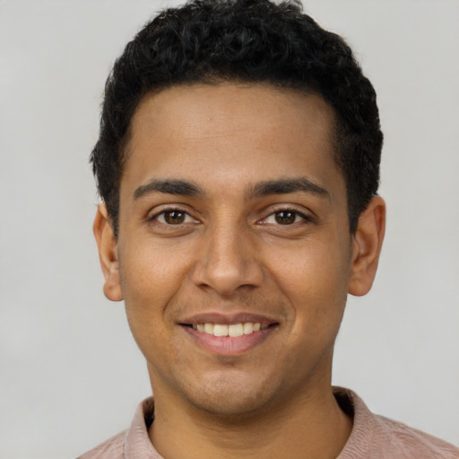 Joyful latino young-adult male with short  black hair and brown eyes
