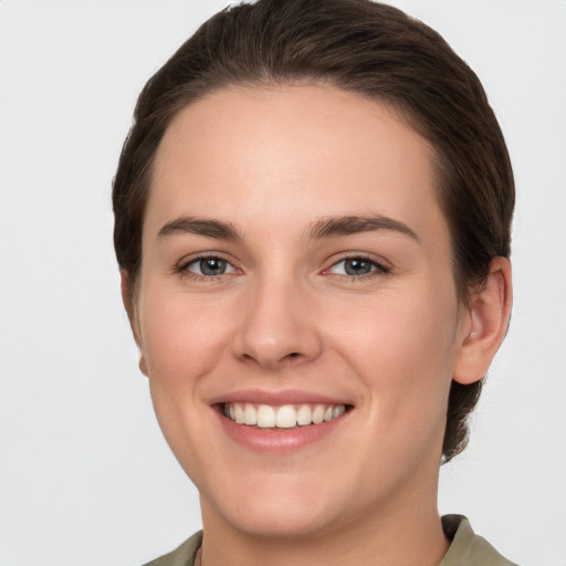 Joyful white young-adult female with short  brown hair and grey eyes