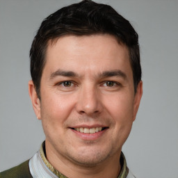 Joyful white young-adult male with short  brown hair and grey eyes