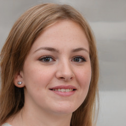 Joyful white young-adult female with long  brown hair and blue eyes