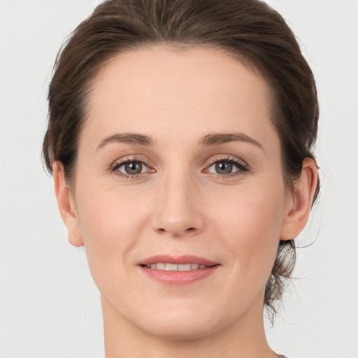 Joyful white young-adult female with medium  brown hair and grey eyes