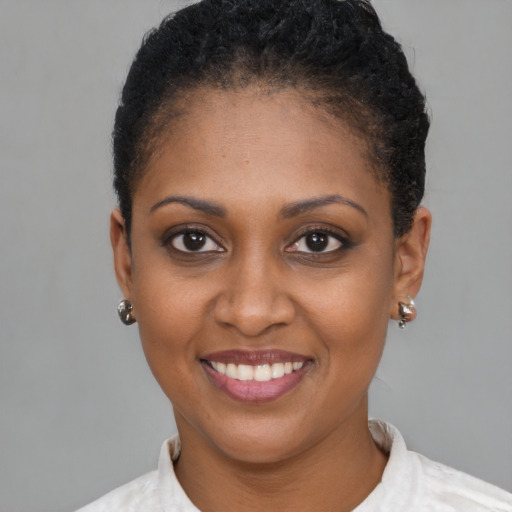 Joyful black young-adult female with short  brown hair and brown eyes