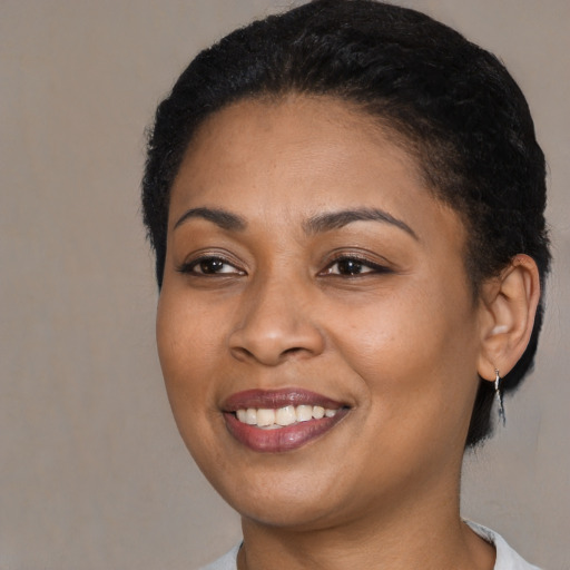 Joyful black young-adult female with short  black hair and brown eyes