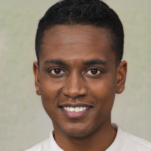 Joyful black young-adult male with short  black hair and brown eyes