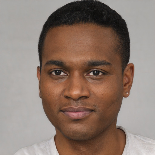 Joyful black young-adult male with short  brown hair and brown eyes