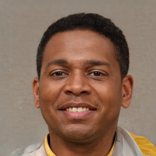 Joyful latino young-adult male with short  brown hair and brown eyes