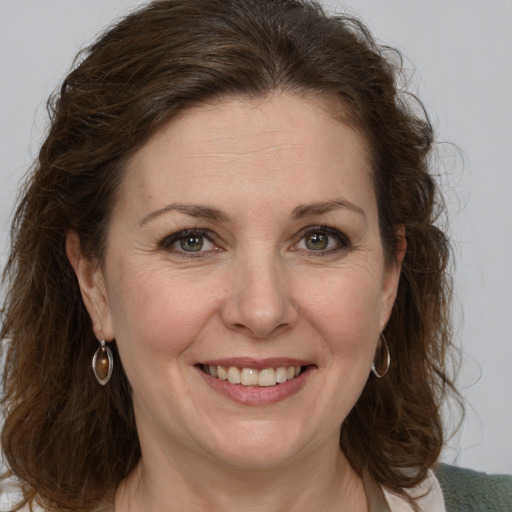 Joyful white adult female with medium  brown hair and grey eyes