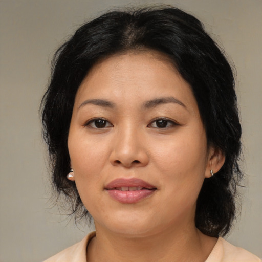 Joyful asian adult female with medium  brown hair and brown eyes