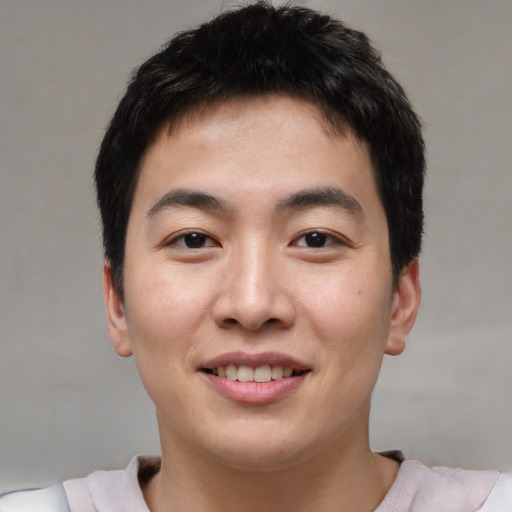 Joyful asian young-adult male with short  brown hair and brown eyes