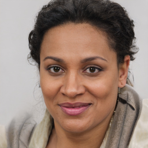 Joyful latino adult female with short  brown hair and brown eyes