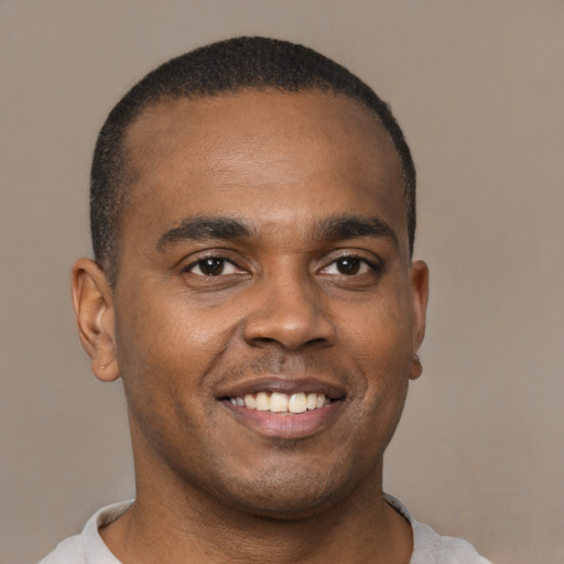 Joyful latino young-adult male with short  brown hair and brown eyes