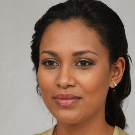 Joyful black young-adult female with medium  brown hair and brown eyes