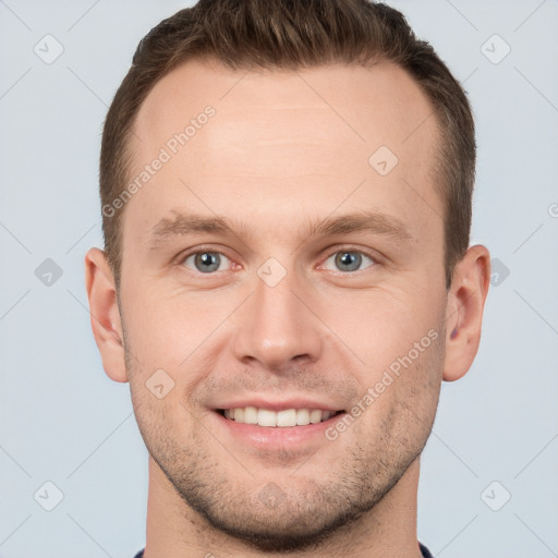 Joyful white young-adult male with short  brown hair and grey eyes