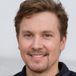 Joyful white adult male with short  brown hair and grey eyes