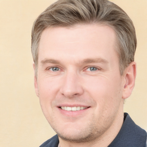 Joyful white young-adult male with short  brown hair and grey eyes