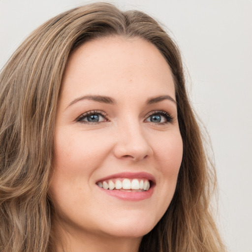 Joyful white young-adult female with long  brown hair and green eyes