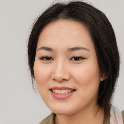 Joyful asian young-adult female with medium  brown hair and brown eyes