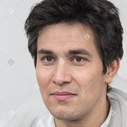 Joyful white adult male with short  brown hair and brown eyes