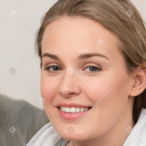 Joyful white young-adult female with medium  brown hair and blue eyes