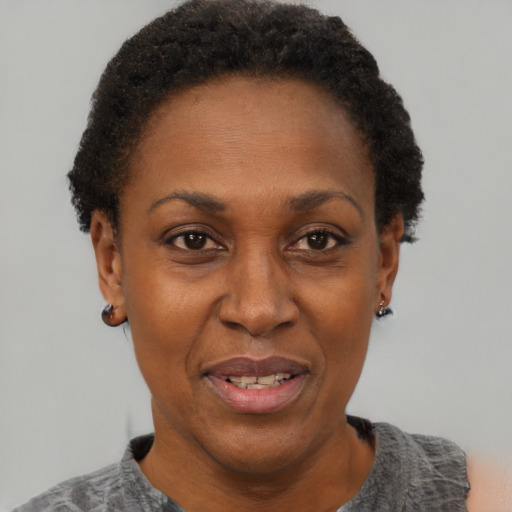 Joyful black adult female with short  black hair and brown eyes