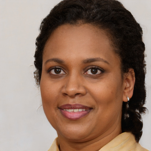 Joyful black adult female with medium  brown hair and brown eyes
