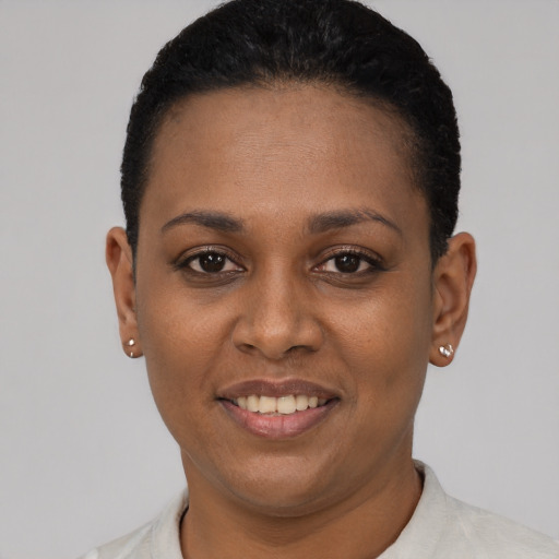 Joyful black young-adult female with short  black hair and brown eyes