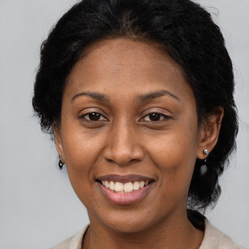 Joyful black adult female with long  brown hair and brown eyes