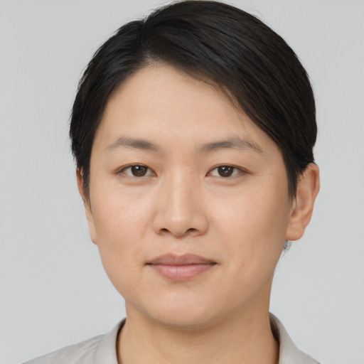Joyful asian young-adult female with short  brown hair and brown eyes